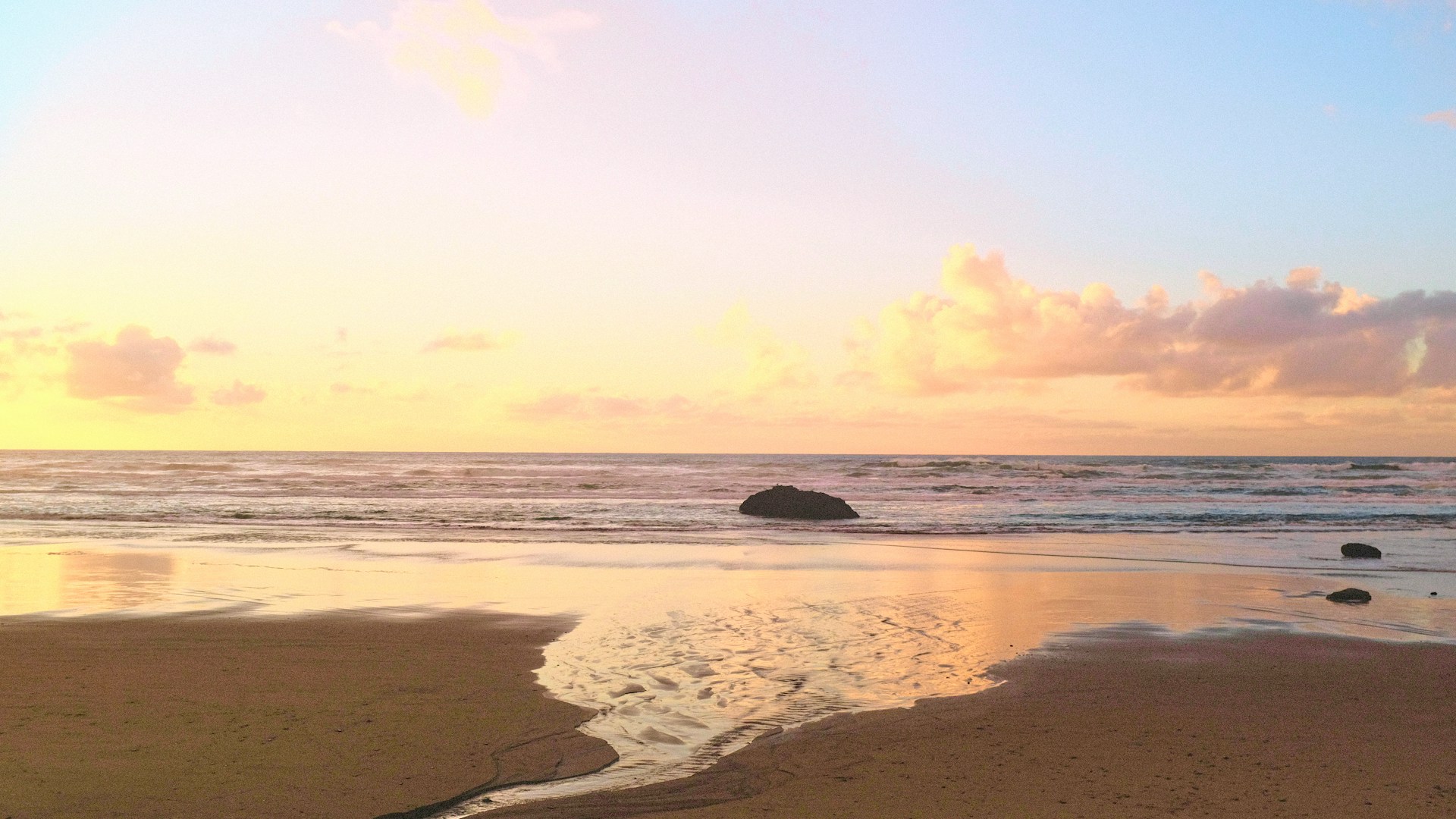 a sandy beach with waves coming in to shore